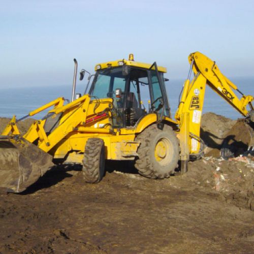 Retroexcavadora amarilla trabajando en terreno